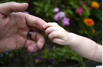 Main d'enfant agripant une main d'adulte